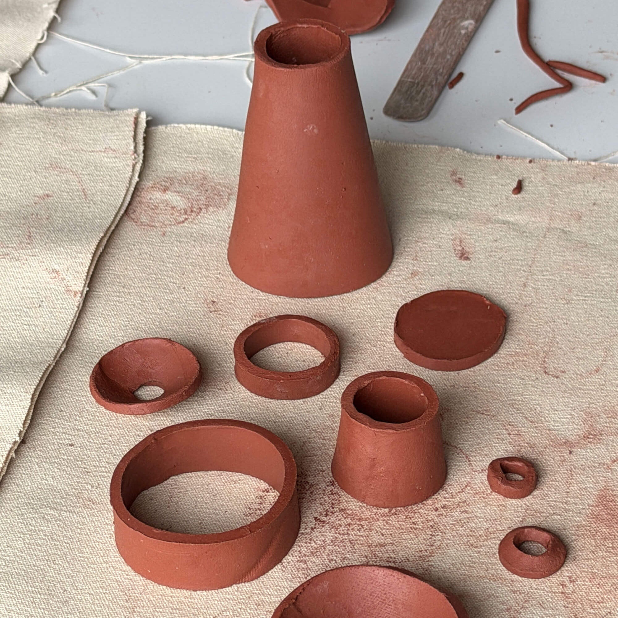 Collection of terracotta pots and pottery forms on a textured surface