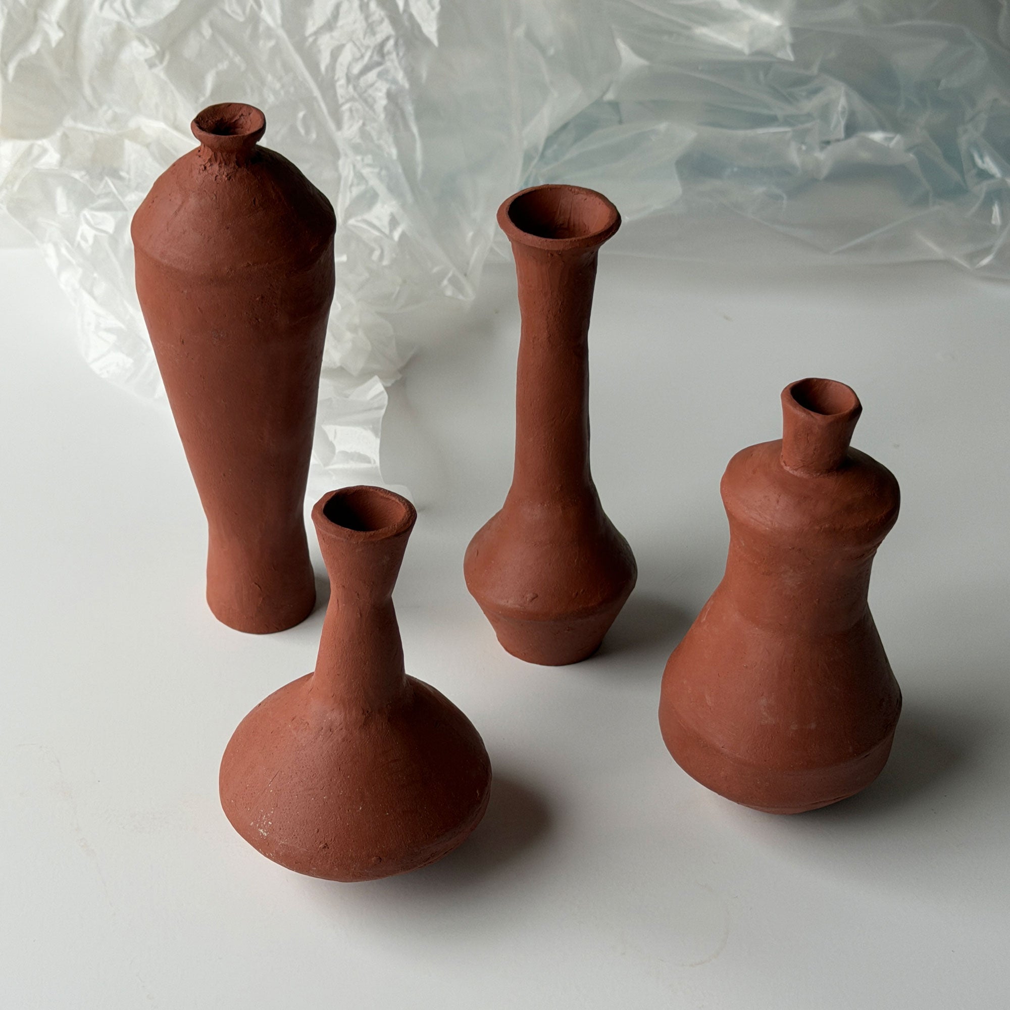 Set of pottery template for four terracotta vases on a white background